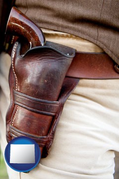 a gun in a Western-style, leather holster - with Wyoming icon